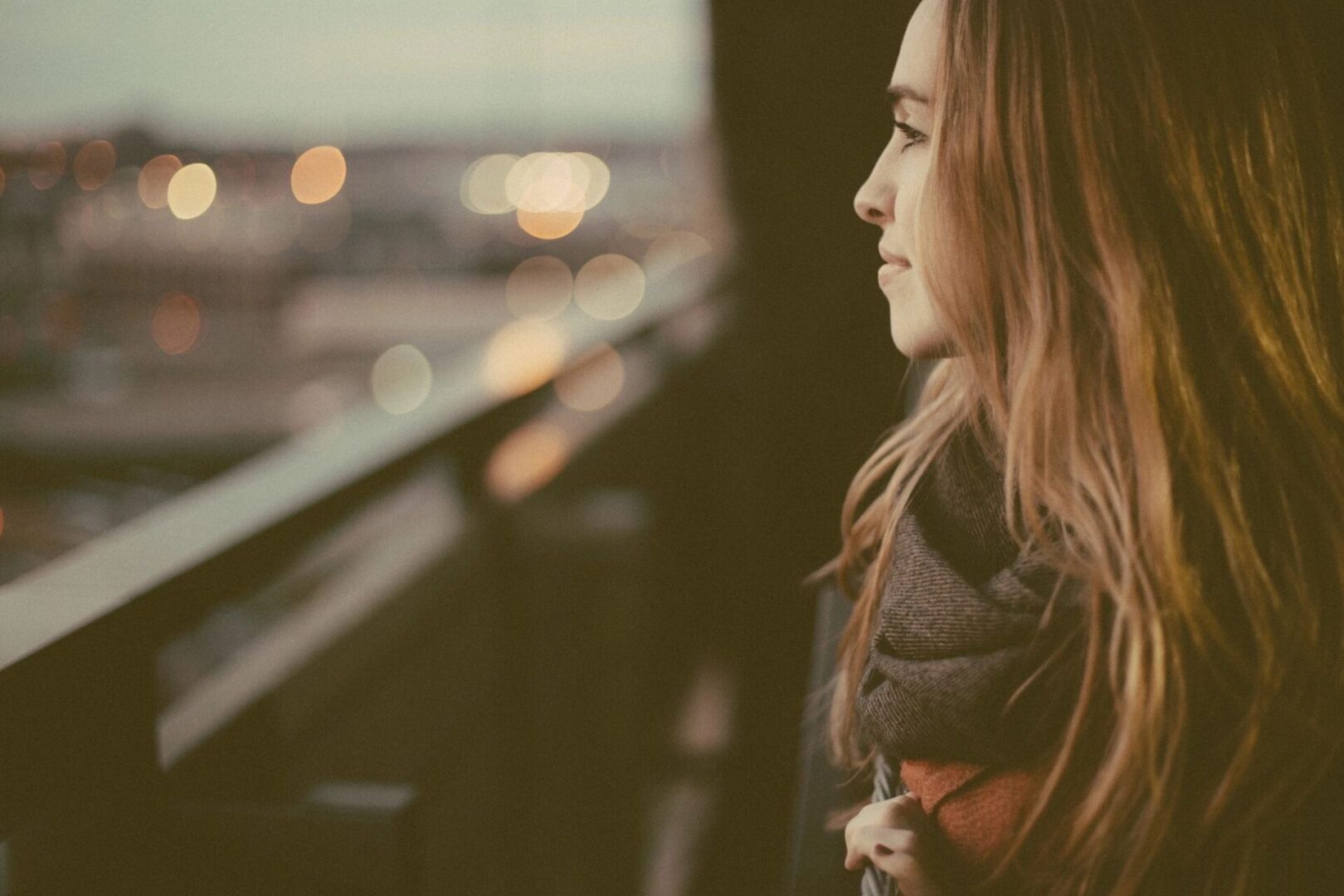 A woman looking out of the window at night.